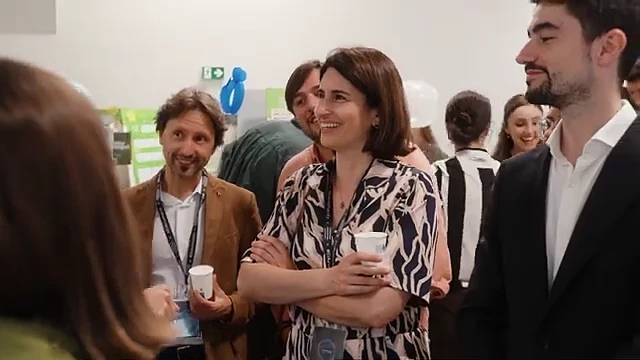 Mentors laughing with founders at a stand