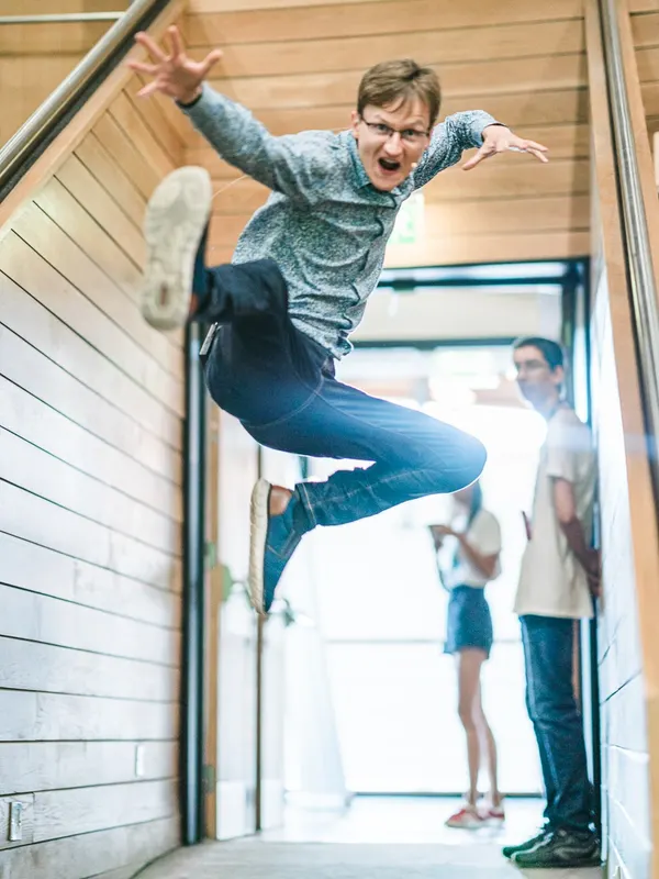 A student leaps in the air on the stairs