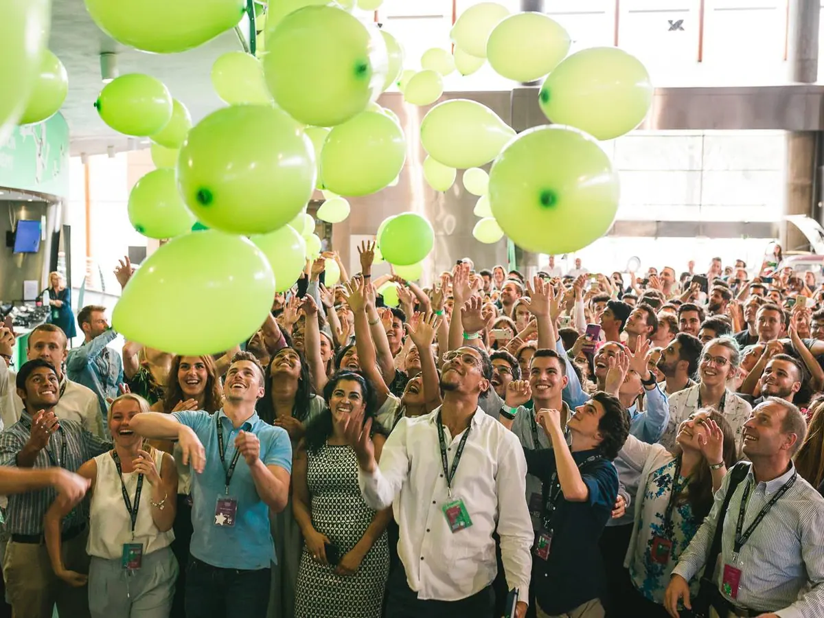 Hundreds of students cheering as green balloons drop over the EIA hall